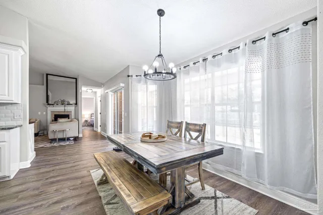 a kitchen with granite countertop a refrigerator a sink a stove and white cabinets