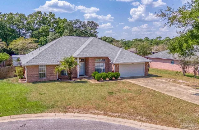 a front view of a house with a garden and yard