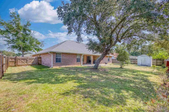 an aerial view of residential houses with outdoor space and trees