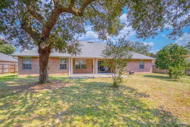 an aerial view of residential houses with outdoor space and trees