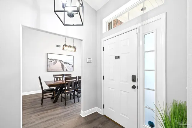 a room with a table chairs and a window