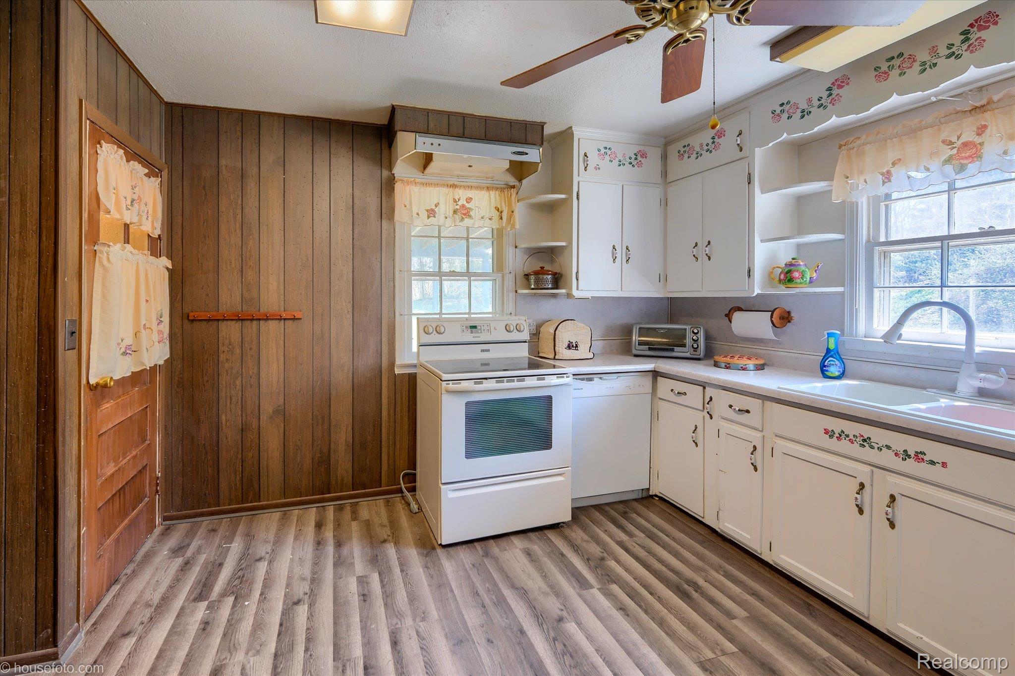 1325 Barnes Lake Road North Branch, MI 48461 - Photo 8 of 42 Kitchen with light countertops, white appliances, white cabinets, ceiling fan, and wood walls