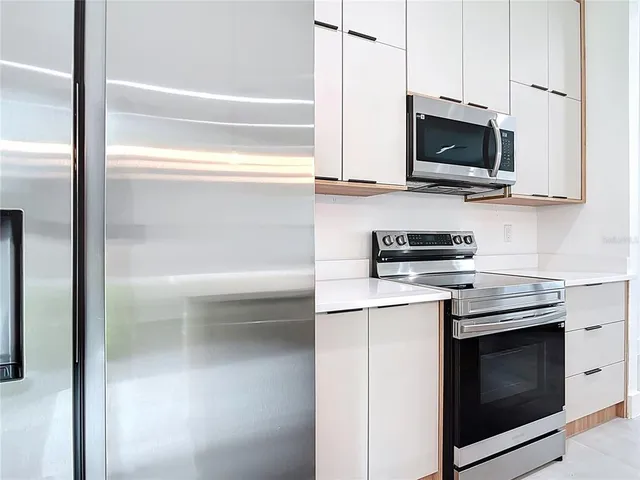 a kitchen with stainless steel appliances a stove a microwave and sink