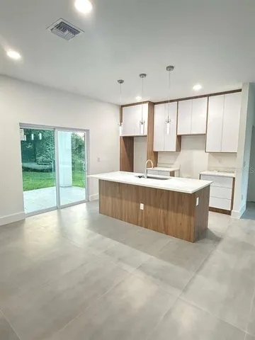 a large kitchen with kitchen island a sink a counter top space and stainless steel appliances