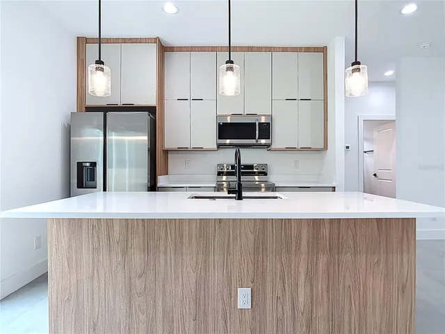a large kitchen with kitchen island a sink stainless steel appliances and cabinets