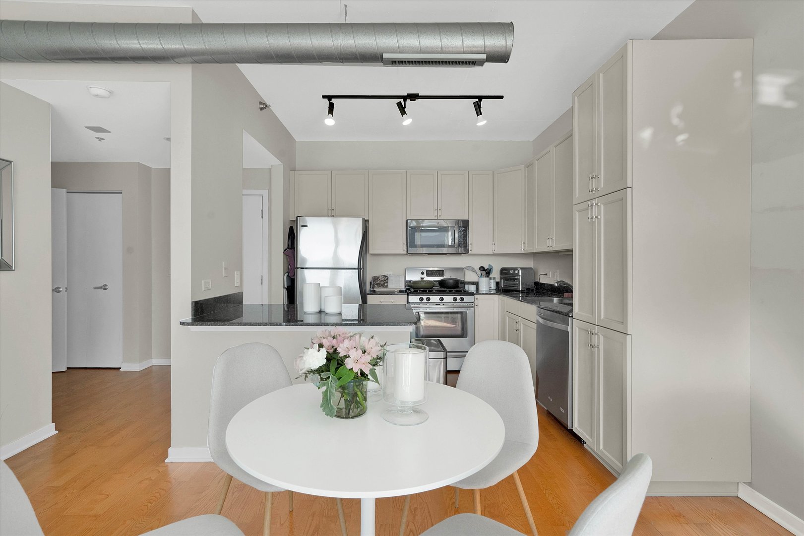 909 West Washington Boulevard, Unit 1002 Chicago, IL 60607 - Photo 3 of 15 a kitchen with stainless steel appliances granite countertop a sink and a refrigerator