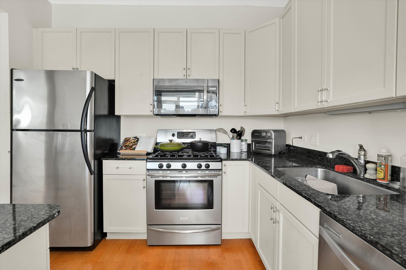 909 West Washington Boulevard, Unit 1002 Chicago, IL 60607 - Photo 4 of 15 a kitchen with refrigerator a stove a sink and white cabinets