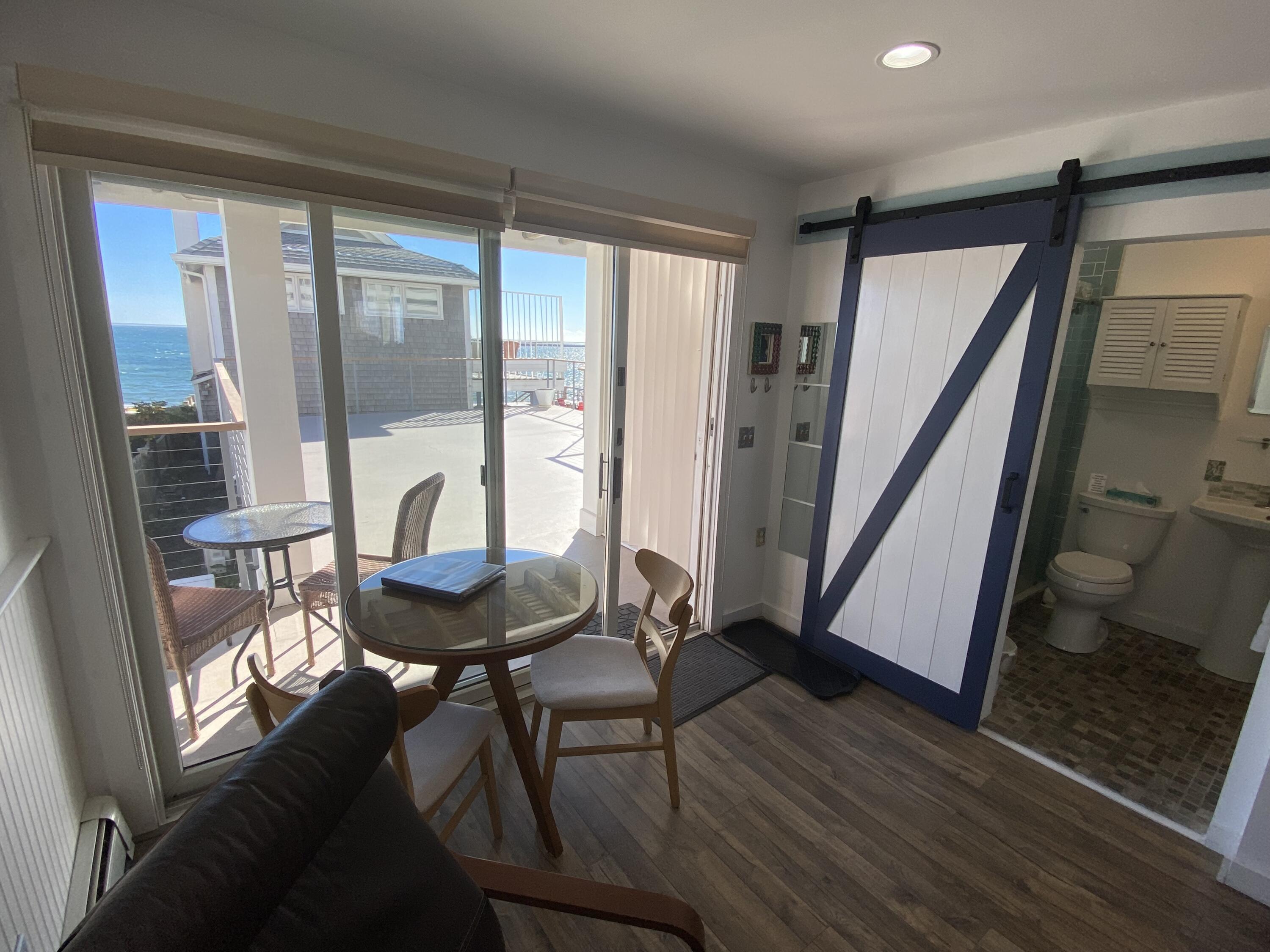 495 Commercial Street, Unit U11 Provincetown, MA 02657 - Photo 8 of 29 a living room with a table chairs and a large window