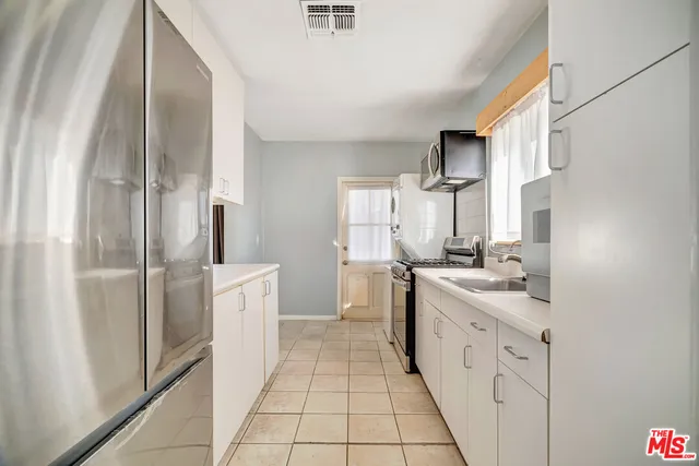 a kitchen with stainless steel appliances a sink stove and refrigerator