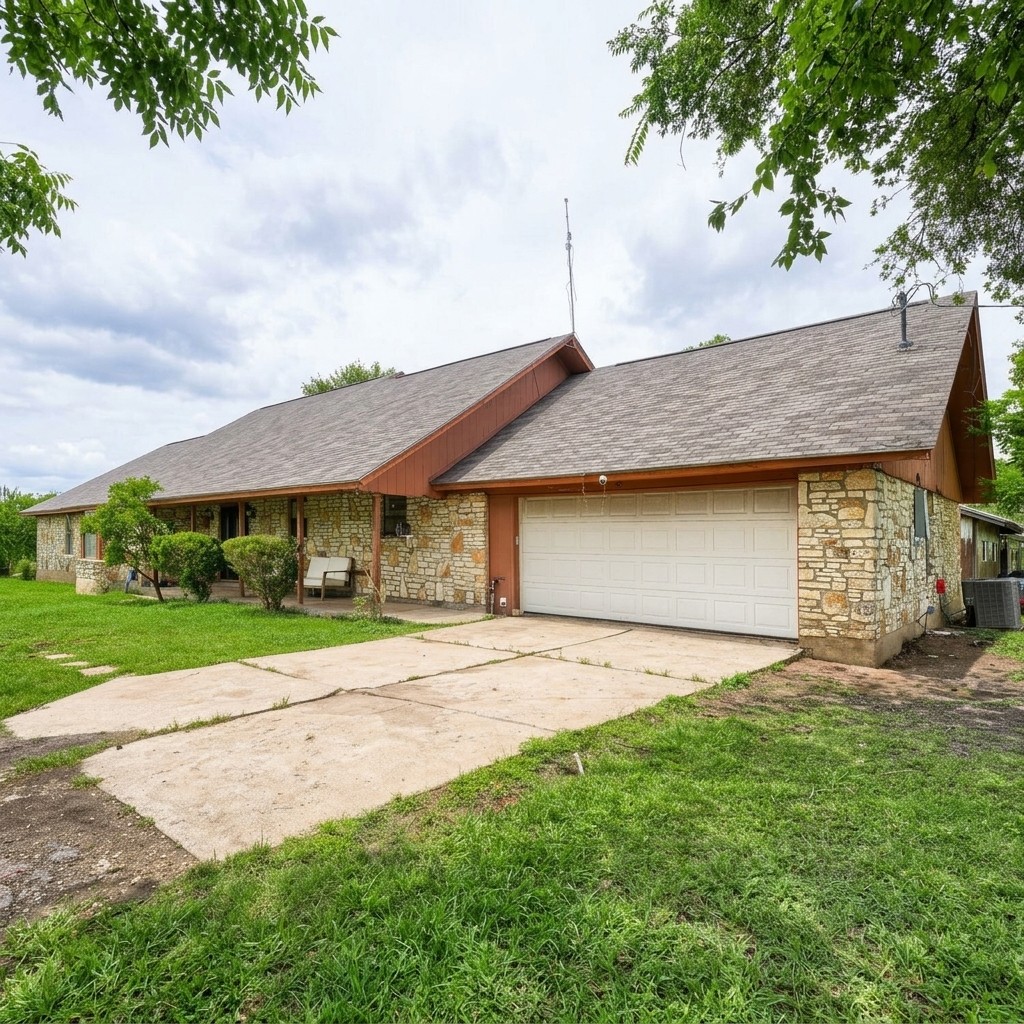 14520 Bois-D-Arc Road Manor, TX 78653 - Photo 18 of 21 a front view of a house with a yard and garage