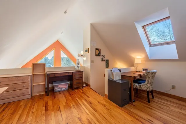 a view of a workspace with furniture and wooden floor