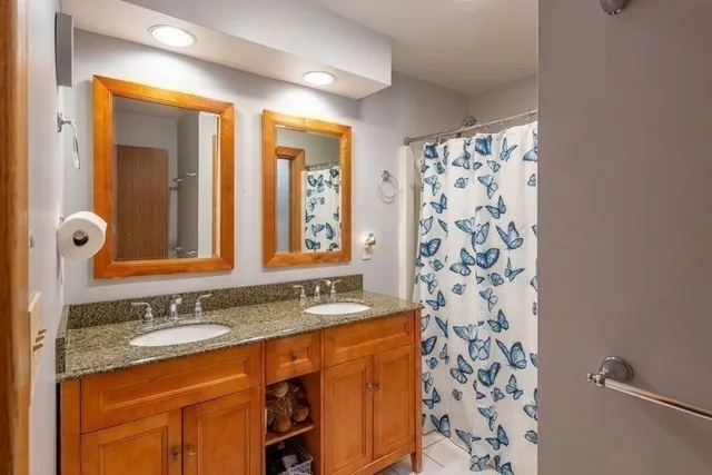 a bathroom with a granite countertop sink a mirror a shower and a mirror