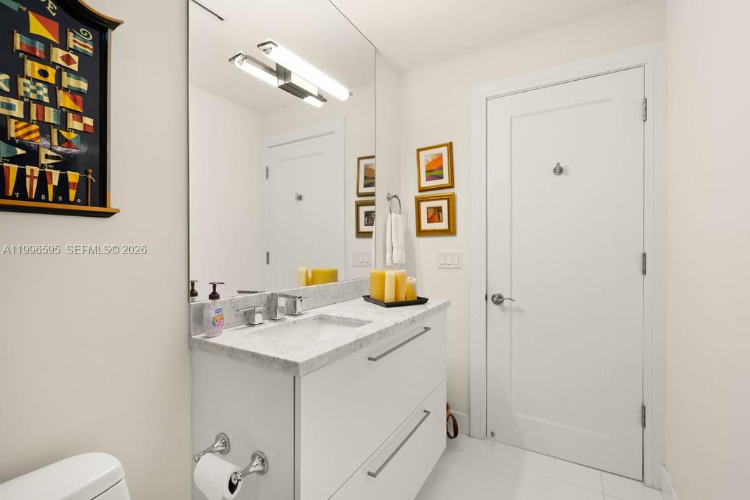 1000 Venetian Way, Unit 105 Miami, FL 33139 - Photo 11 of 49 a bathroom with a sink mirror and vanity