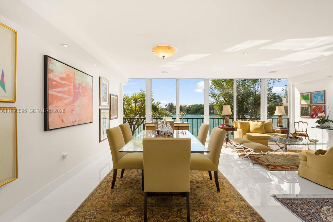 1000 Venetian Way, Unit 105 Miami, FL 33139 - Photo 16 of 49 a dining room with furniture a rug and a floor to ceiling window