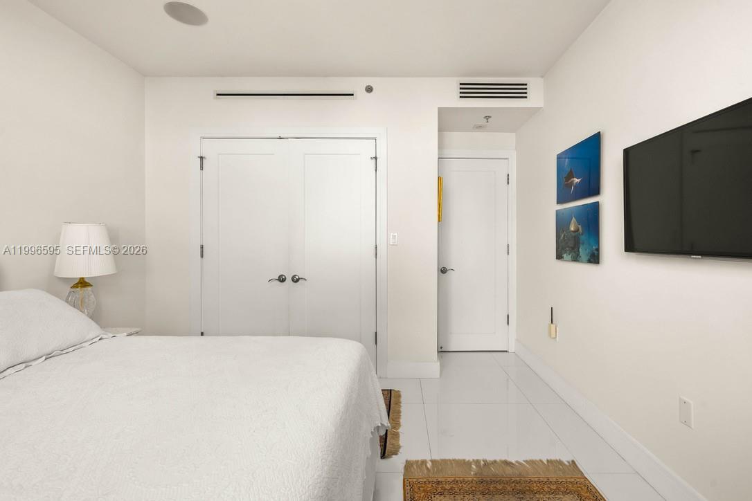 1000 Venetian Way, Unit 105 Miami, FL 33139 - Photo 21 of 49 a bedroom with a bed and a flat screen tv