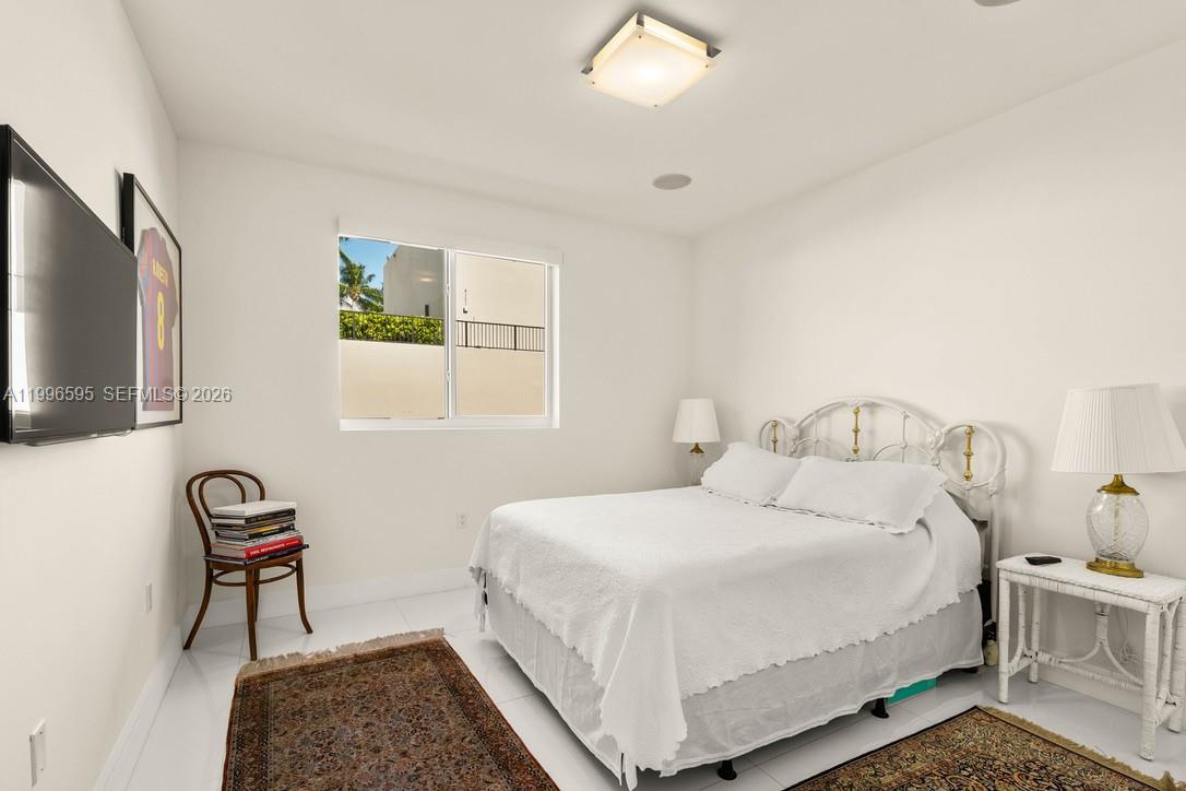 1000 Venetian Way, Unit 105 Miami, FL 33139 - Photo 23 of 49 a bedroom with a bed and a window