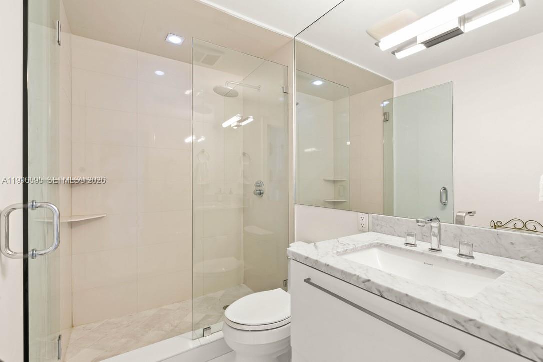 1000 Venetian Way, Unit 105 Miami, FL 33139 - Photo 24 of 49 a bathroom with a granite countertop sink a toilet and shower