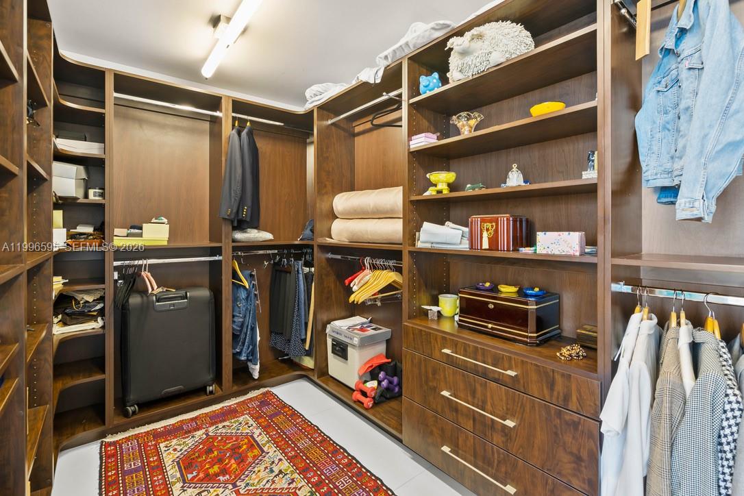 1000 Venetian Way, Unit 105 Miami, FL 33139 - Photo 29 of 49 a view of walk in closet with clothes and shoes