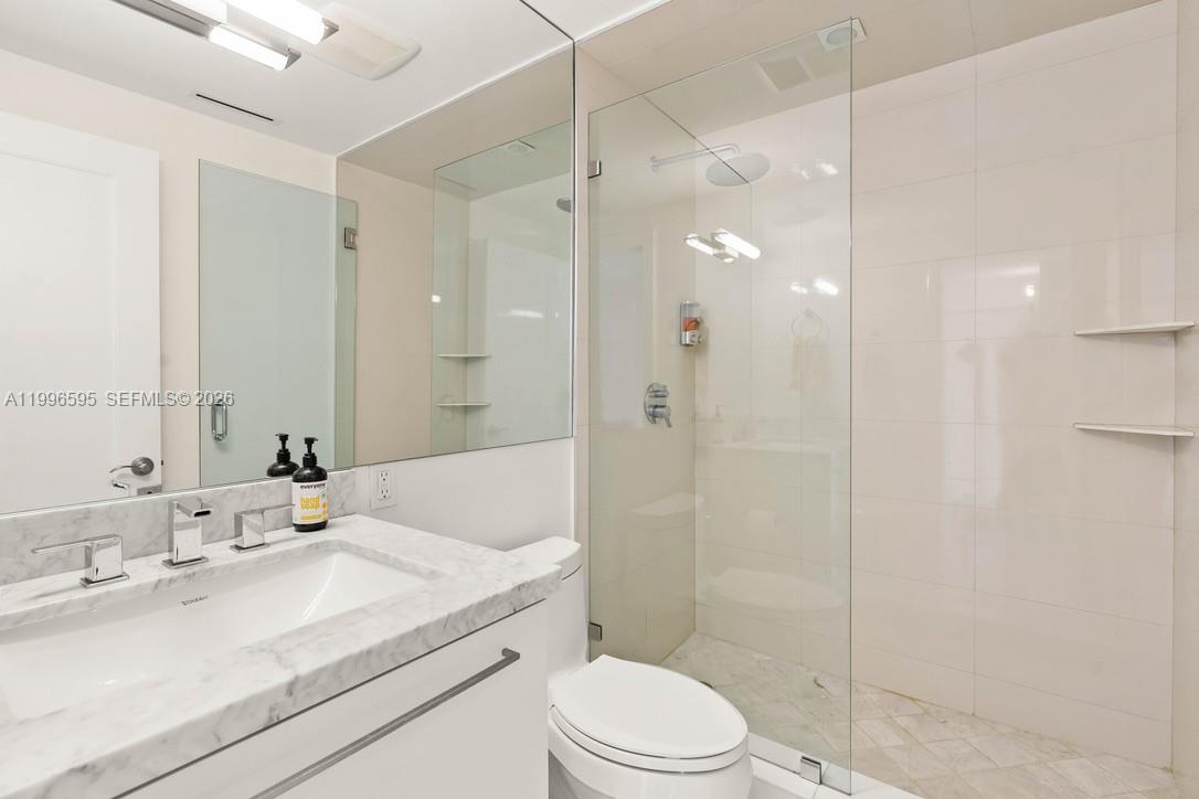 1000 Venetian Way, Unit 105 Miami, FL 33139 - Photo 31 of 49 a bathroom with a sink a toilet and shower