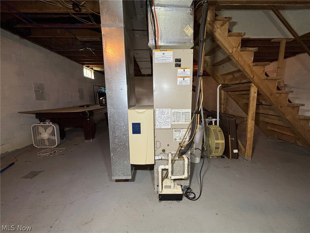 57575 Marietta Road Byesville, OH 43723 - Photo 18 of 25 Basement utility area featuring a forced-air furnace, exposed wood ceiling joists, and a partial wood staircase