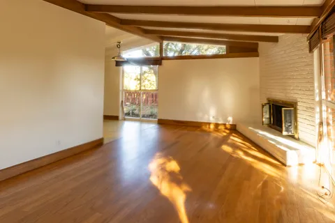 a view of a room with wooden floor and a window