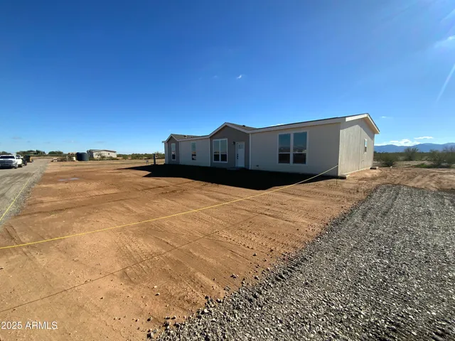 a view of a dry yard with wooden fence
