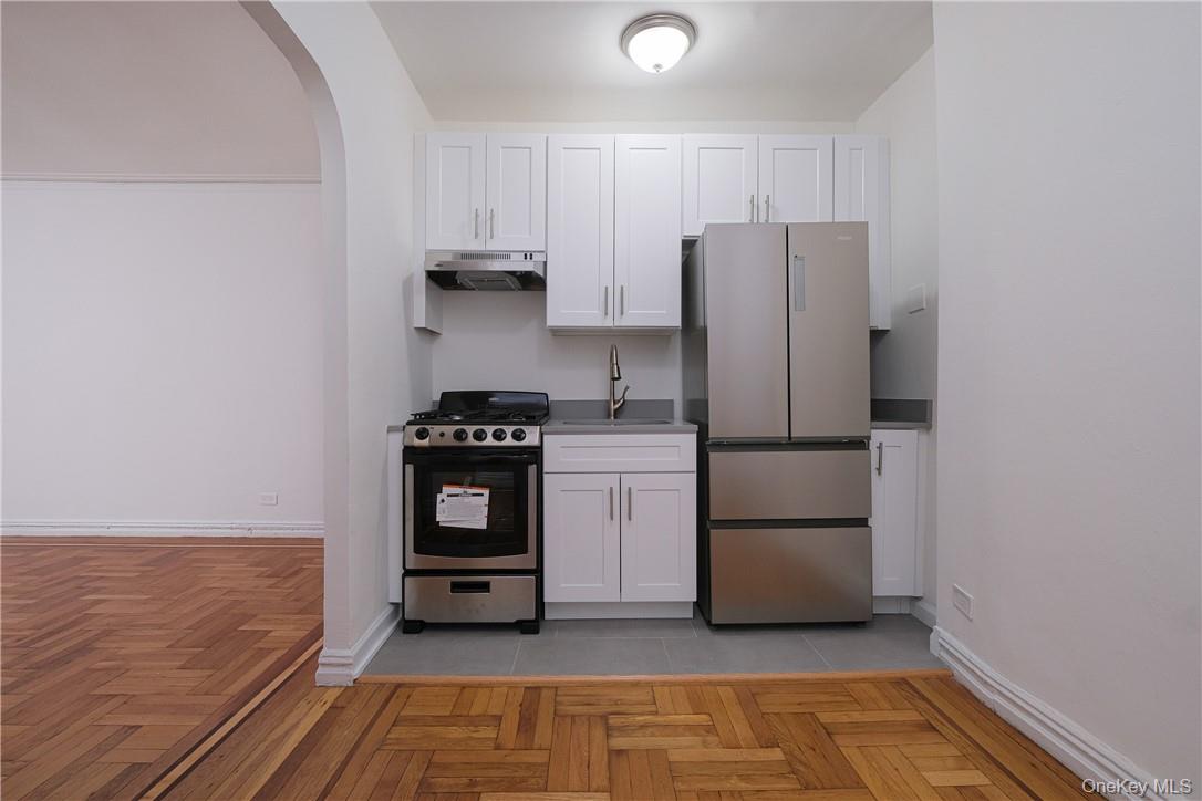 2685 Creston Avenue, Unit 1K Bronx, NY 10468 - Photo 4 of 7 a kitchen with a refrigerator and a stove top oven