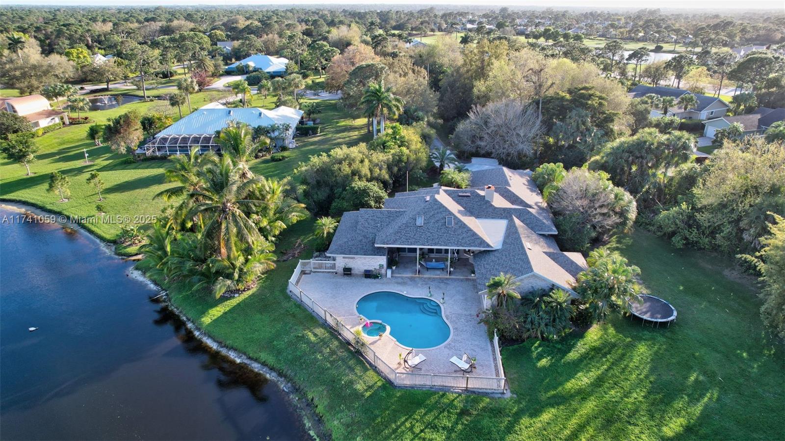 an aerial view of residential houses with outdoor space and trees