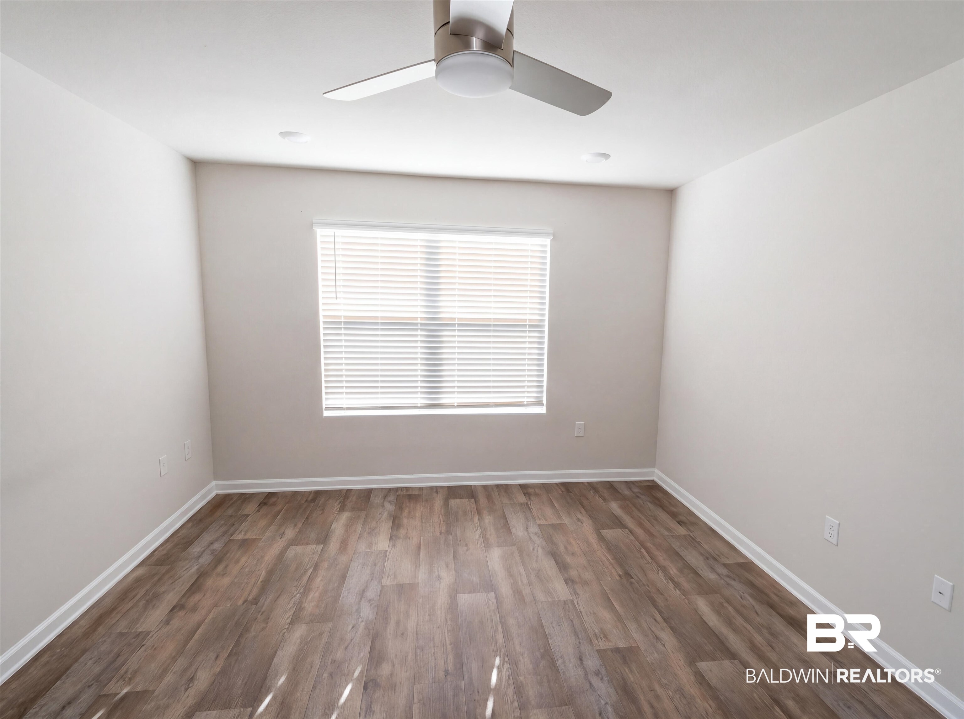 7453 Brompton Drive Foley, AL 36535 - Photo 12 of 15 Spacious room featuring wood-finish flooring, a window with blinds, recessed lighting, a modern ceiling fan, and crisp white baseboards