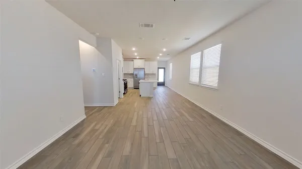 a view of a living room with wooden floor and a window
