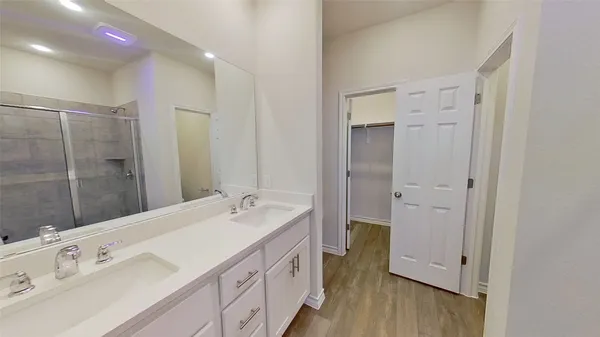 a spacious bathroom with a double vanity sink mirror and shower