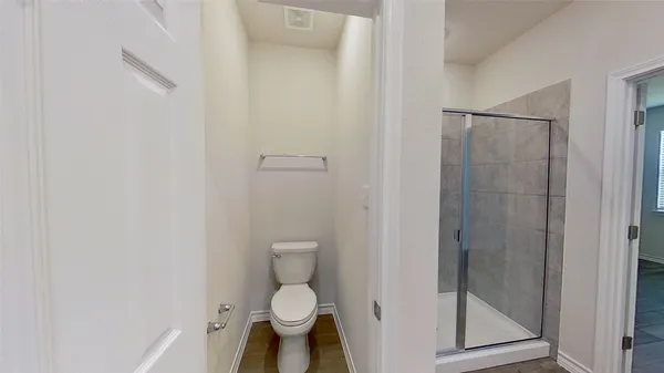 a bathroom with a toilet and a shower