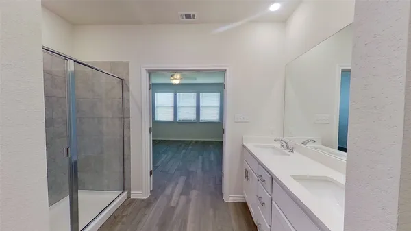 a bathroom with a double vanity sink and mirror with shower