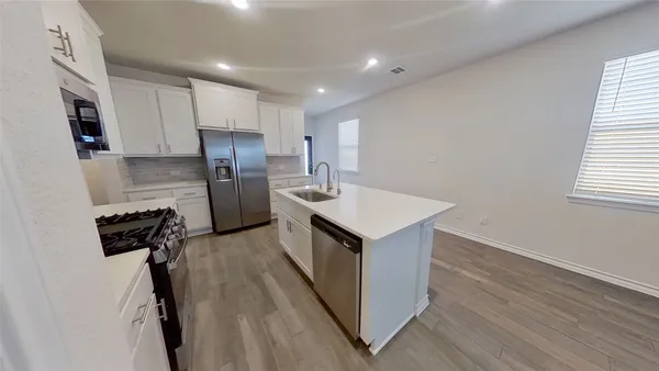 a kitchen with refrigerator cabinets and wooden floor