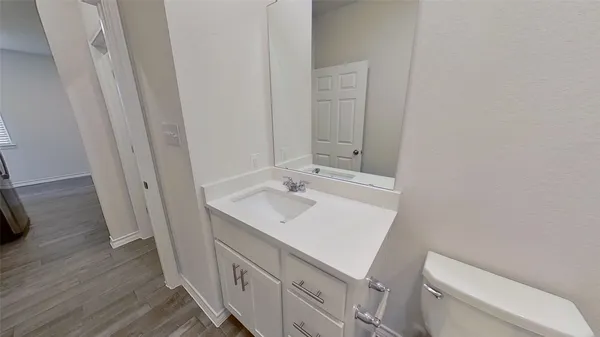 a bathroom with a sink a toilet a mirror and vanity