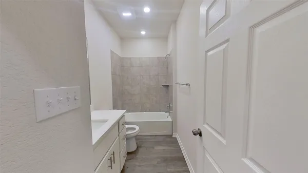 a bathroom with a bathtub shower sink mirror and toilet