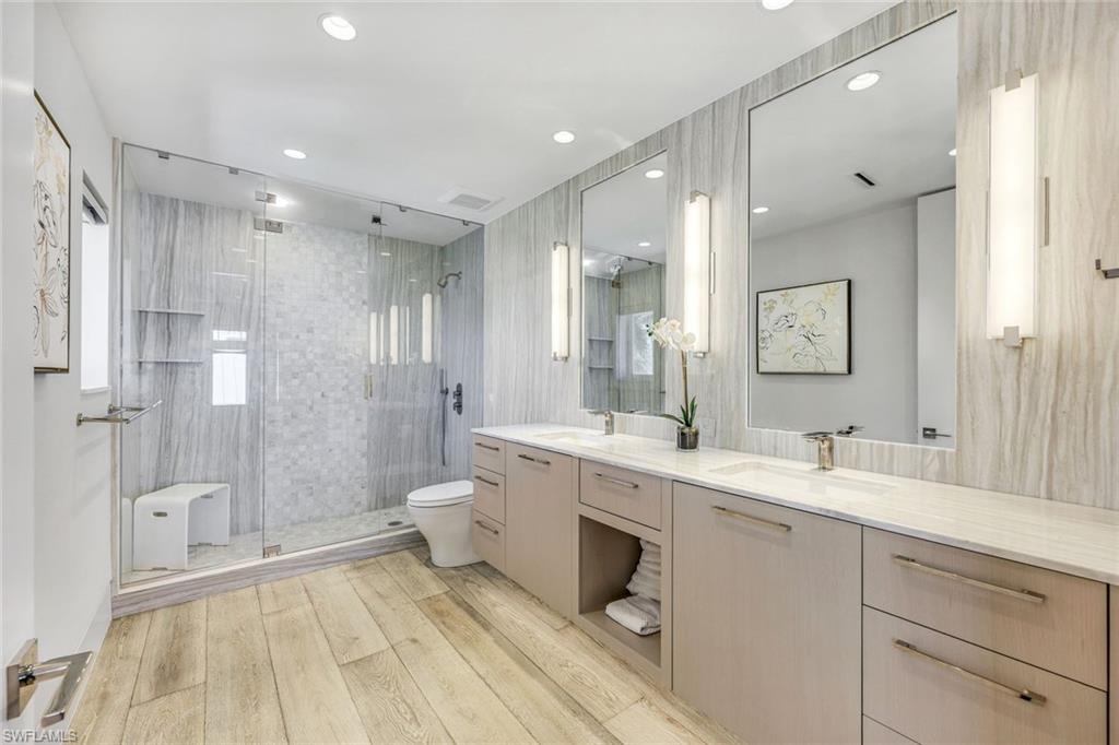 295 5th Avenue South Naples, FL 34102 - Photo 16 of 29 a spacious bathroom with a double vanity sink mirror double and shower