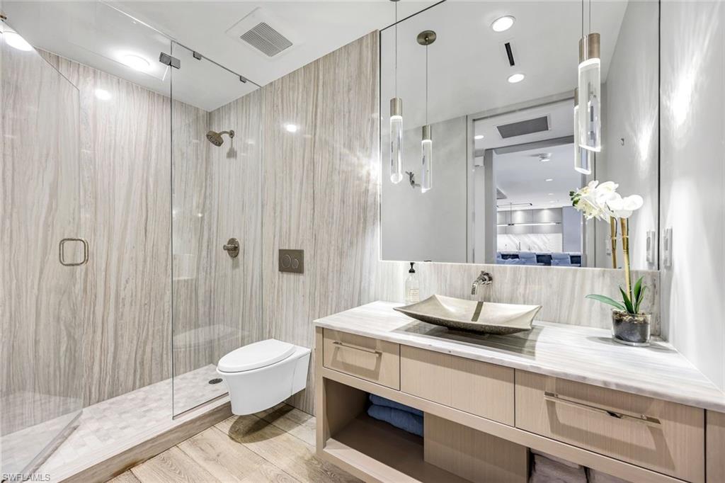 295 5th Avenue South Naples, FL 34102 - Photo 19 of 29 a spacious bathroom with a double vanity sink toilet and shower