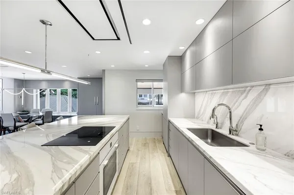 a kitchen with stainless steel appliances a sink a stove top oven a counter space and cabinets