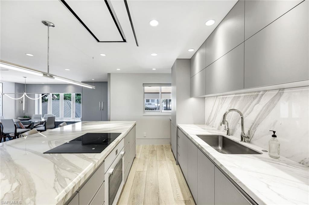 295 5th Avenue South Naples, FL 34102 - Photo 9 of 29 a kitchen with stainless steel appliances a sink a stove top oven a counter space and cabinets