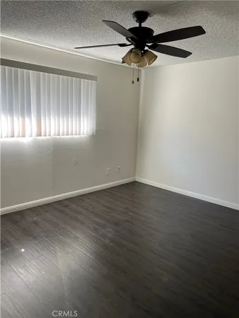 en empty room with wooden floor fan and windows