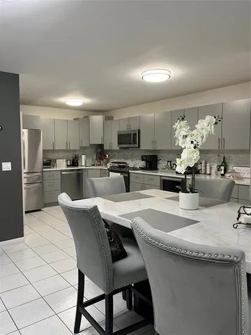 a kitchen with granite countertop a sink stainless steel appliances and white cabinets