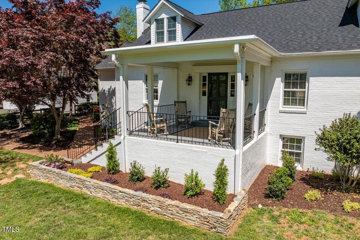 a view of a white house with large windows and a table and chairs