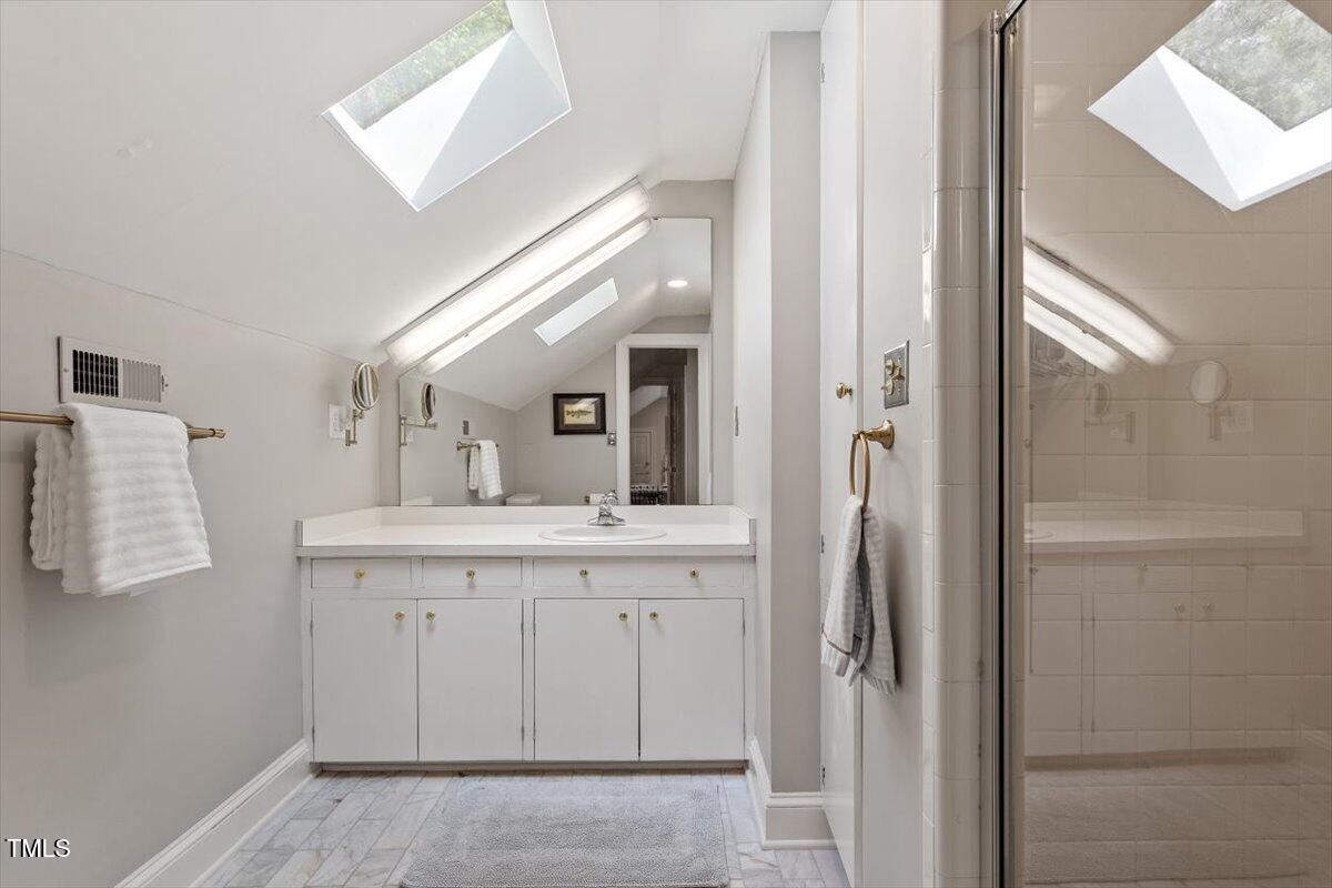 5212 Theys Road Raleigh, NC 27606 - Photo 22 of 56 a spacious bathroom with a granite countertop sink and a mirror