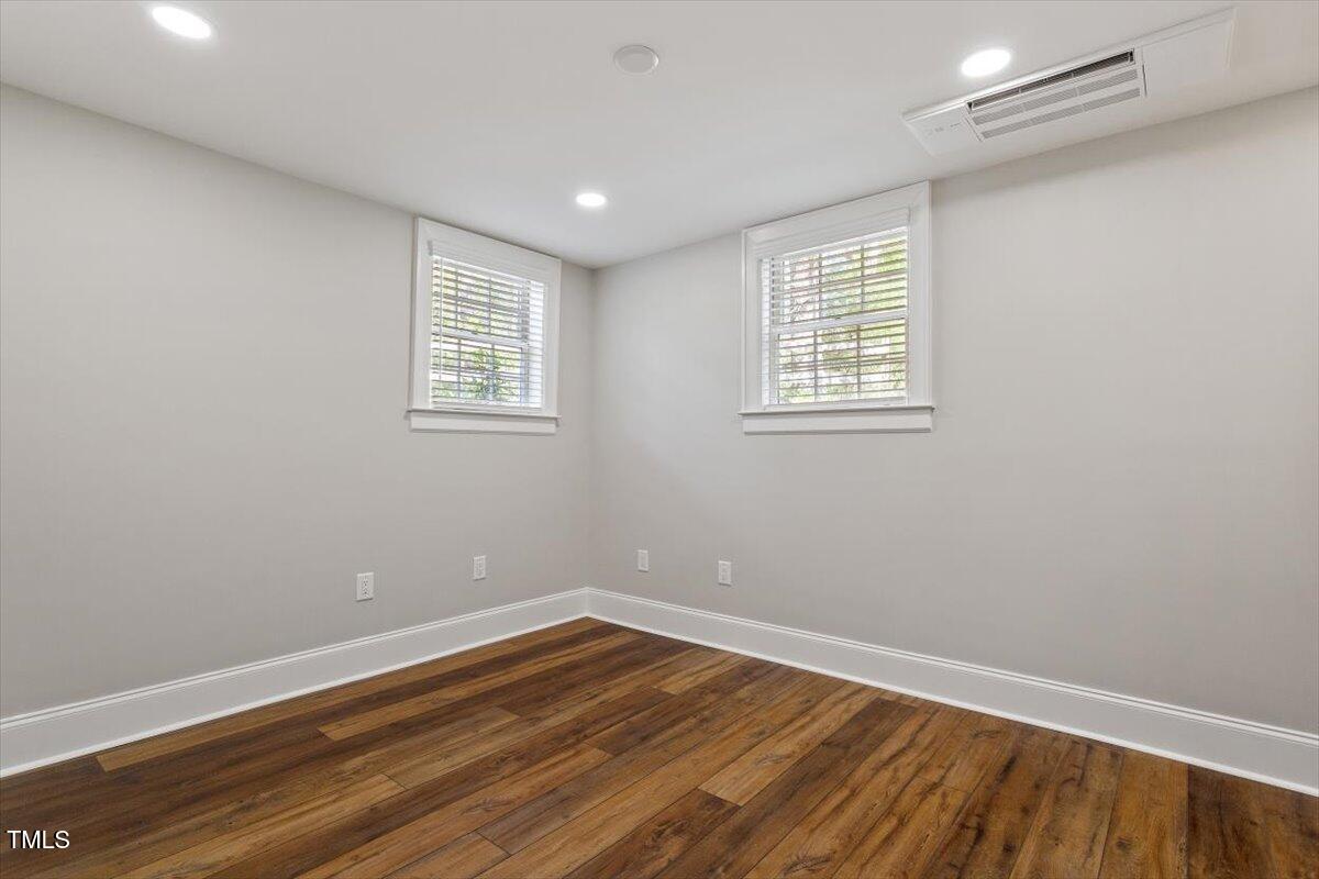 5212 Theys Road Raleigh, NC 27606 - Photo 26 of 56 a view of an empty room with wooden floor and a window