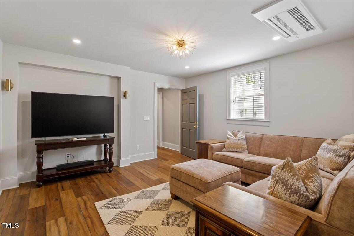 5212 Theys Road Raleigh, NC 27606 - Photo 31 of 56 a living room with furniture and a flat screen tv