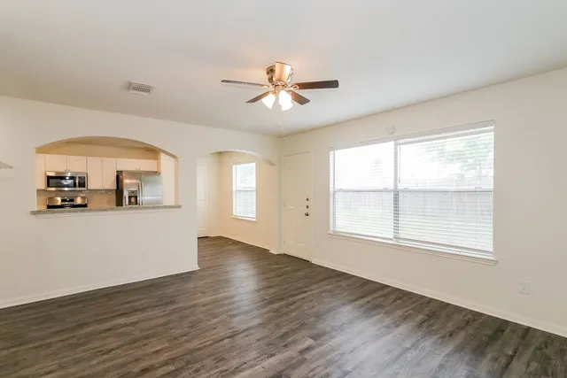 an empty room with wooden floor and a window