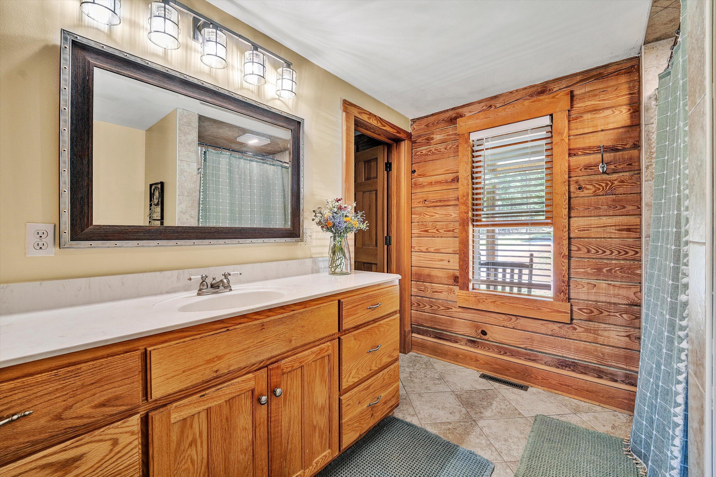180 Thompson Ridge Circle Ferrum, VA 24088 - Photo 27 of 74 a bathroom with a sink mirror and a bathtub next to a window