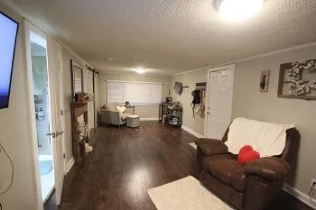 a living room with furniture and a wooden floor