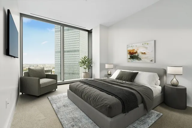 a bedroom with bed couch and window